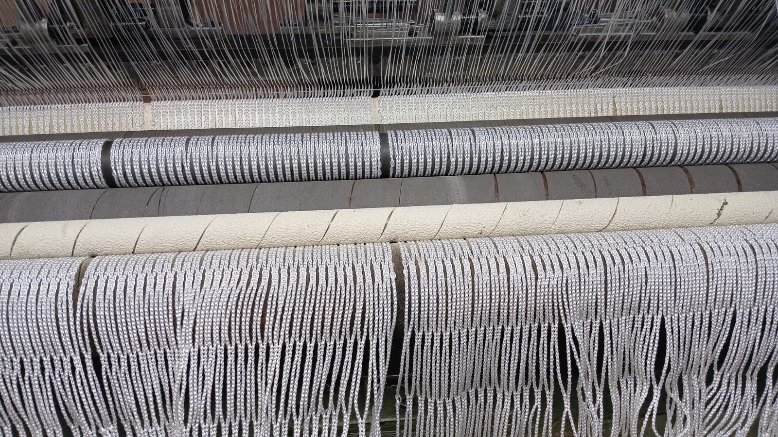 Máquina de tear produzindo rede de proteção em fios de polietileno na fábrica da Lineos